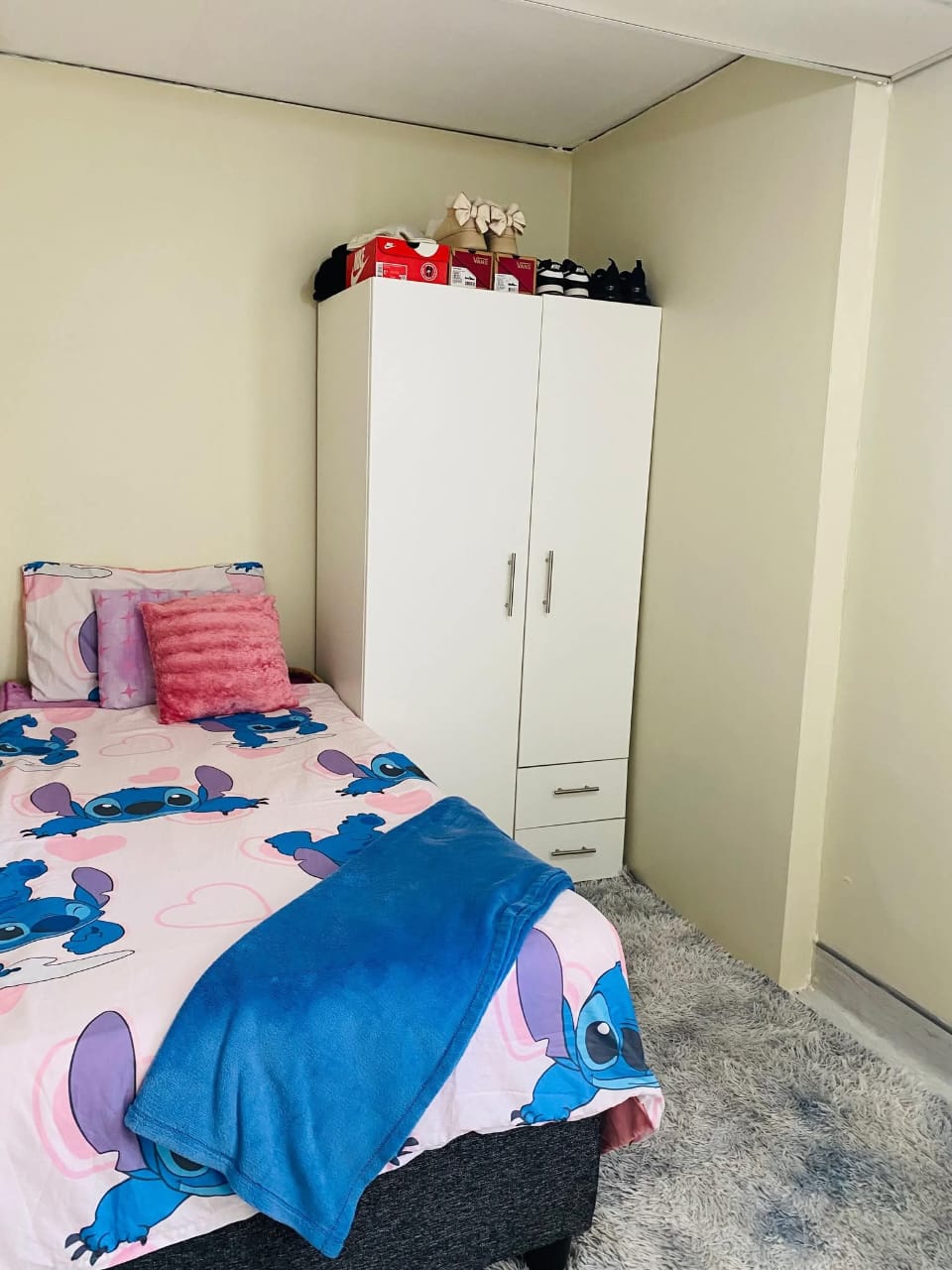 Victoria Gardens bedroom with a bed and white wardrobe
